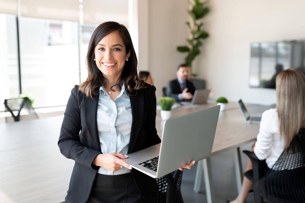 Executiva segurando um notebook representando o post de gestão de custos e planejamento estratégico