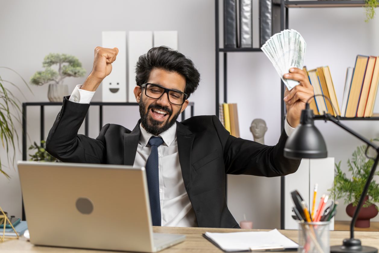 Homem comemorando com dinheiro na mão representando o post sobre paz entre os setores de compras e financeiro