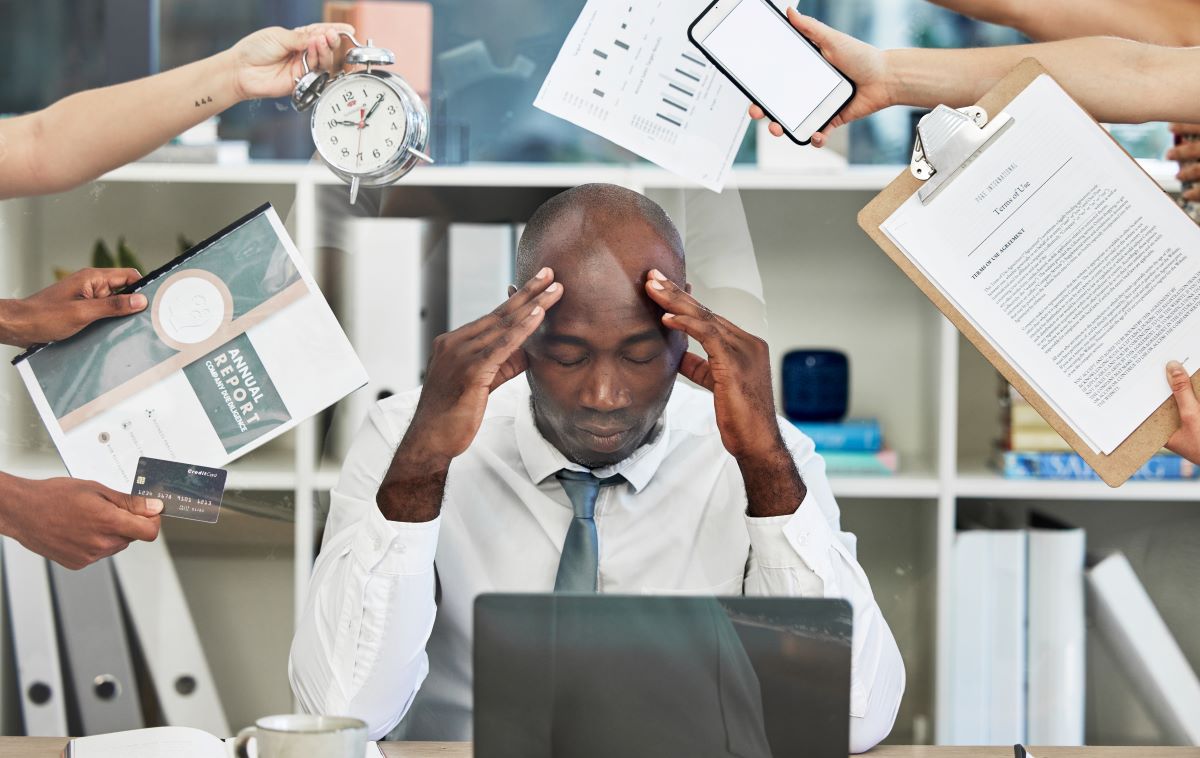 Homem com muitas tarefas representando o post sobre perda de tempo em atividades administrativas