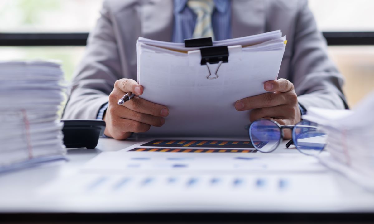 Homem segurando documentos representando o post sobre vantagens da nota fiscal