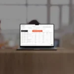 Notebook sobre uma mesa de madeira exibindo a ferramenta de consulta gratuita da Tabela NCM 2026 da Qive