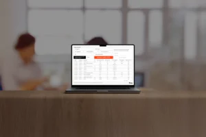 Notebook sobre uma mesa de madeira exibindo a ferramenta de consulta gratuita da Tabela NCM 2026 da Qive